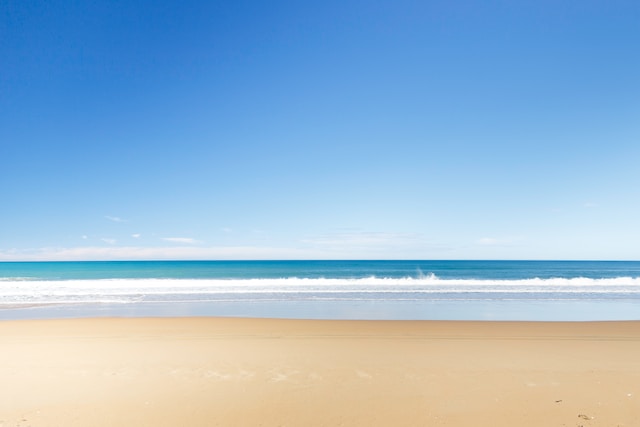 Landscape photograph showing sand, water and blue sky