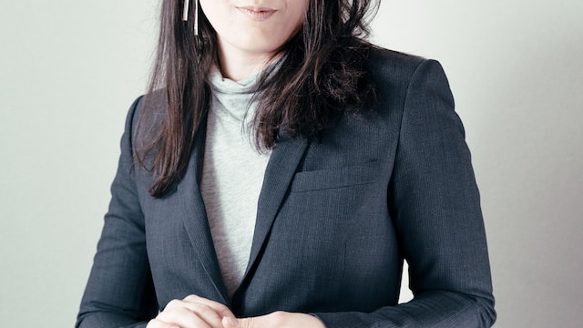 Woman wearing a gray suit jacket and light-gray top